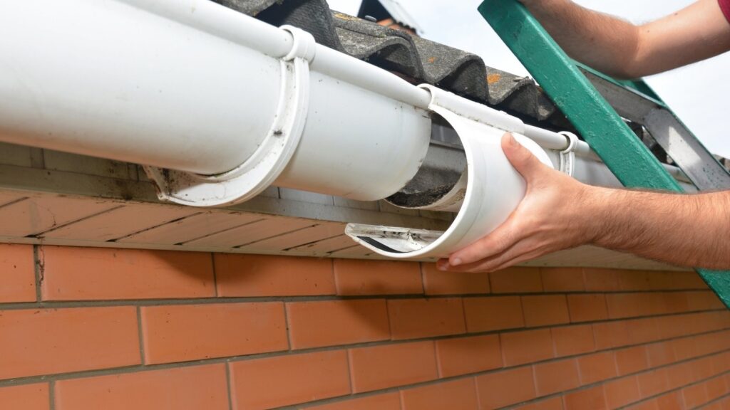 Gutter cleaning vs. gutter replacement comparison, showing a clogged gutter with leaves beside a newly installed gutter, with key warning signs, cost comparison, and Irish weather impact.
